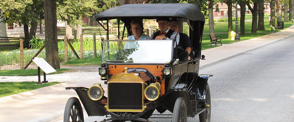 People driving a Ford Model T on a country road